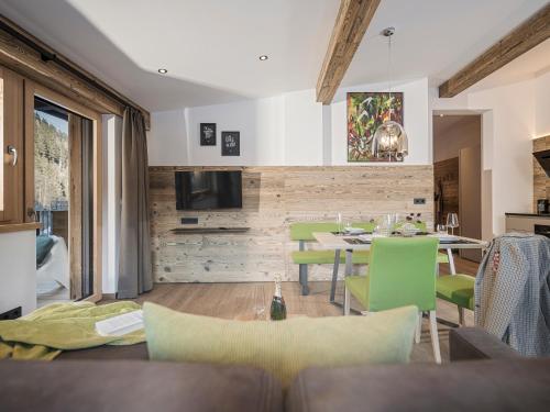 a living room with a table and green chairs at LENZup Apartments in Mayrhofen