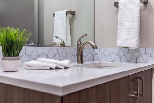a bathroom counter with a sink and a mirror at Riverfront Park Travel Apartments in Spokane