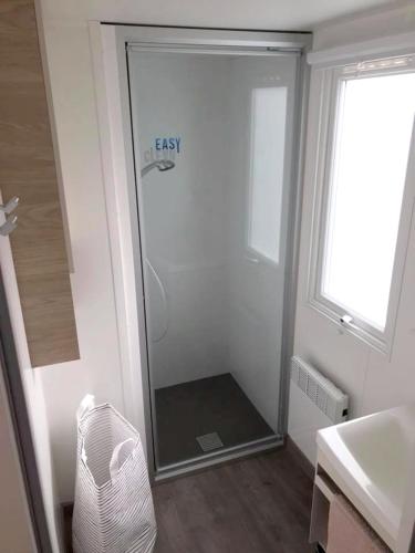 une douche avec une porte vitrée dans une salle de bain dans l'établissement Bungalow paisible à Saint-Jean-de-Monts avec piscine partagée, à Saint-Jean-de-Monts