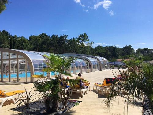 - un complexe avec une piscine et des chaises dans l'établissement Bungalow paisible à Saint-Jean-de-Monts avec piscine partagée, à Saint-Jean-de-Monts