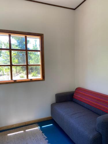a living room with a couch and a window at Geotermas Spa de Montaña in Antuco