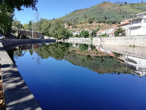 a body of water next to a stone wall at Casarão do Alva in Penalva de Alva