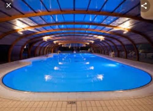 uma grande piscina com água azul num edifício em Sublima em Litteau