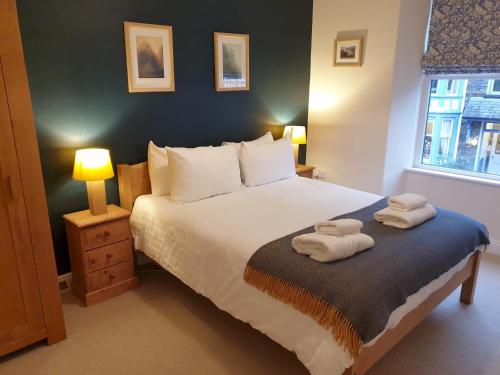 a bedroom with a bed with two towels on it at Holmdale, Ambleside in Ambleside