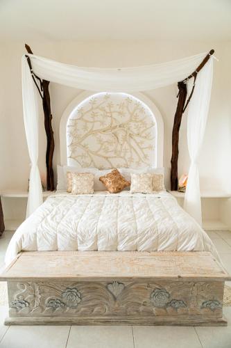 a bedroom with a large bed with a canopy at Hotel Pasión de Luna in Puerto Ángel
