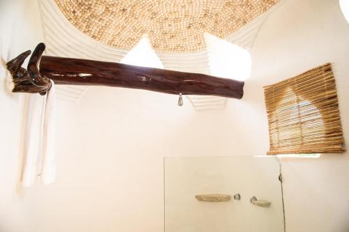 a branch hanging from the ceiling of a bathroom at Hotel Pasión de Luna in Puerto Ángel