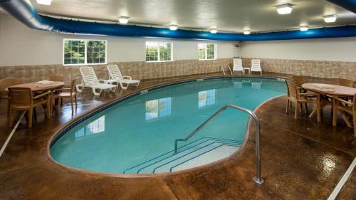 a large pool with tables and chairs in a building at Irish Cottage Inn & Suites in Galena