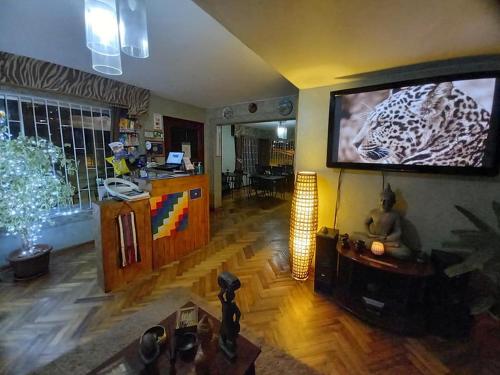 sala de estar con TV de pantalla plana en la pared en Hostal Tunquelen, en Valparaíso