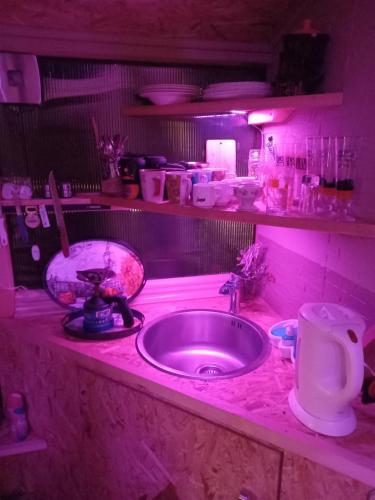 a kitchen counter with a sink and pink lighting at Holiday Home Nature Neno in Visoko