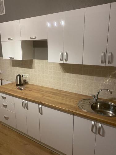 a kitchen with white cabinets and a sink at Ehostel360 in Ivano-Frankivsʼk