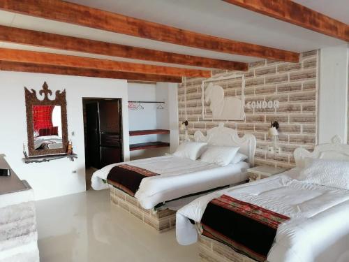 a bedroom with two beds and a brick wall at Casa de Sal - Salt Hotel in Uyuni
