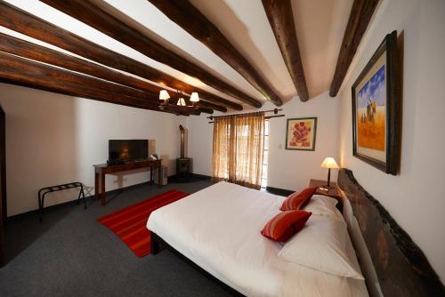 1 dormitorio con 1 cama blanca grande y TV en Amak Valle Sagrado, en Urubamba