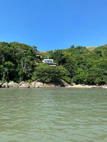 a house on a hill above a body of water at Casa Luz in Paraty