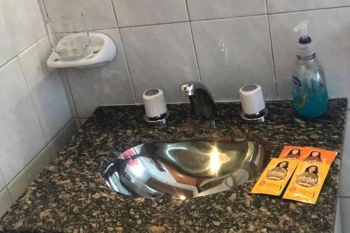 a bathroom counter with a sink and a book at Departamento ALUMA in San Rafael