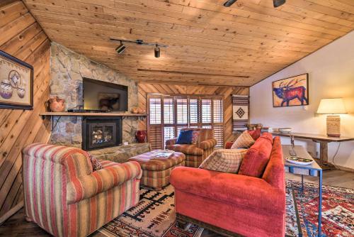 a living room with couches and a stone fireplace at Lovely New Mexico Retreat with 4 Private Balconies! in Angel Fire