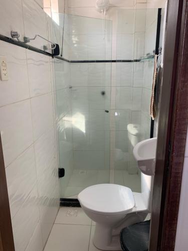 a bathroom with a shower and a toilet and a sink at CASA NA PRAÇA DE AREMBEPE in Arembepe