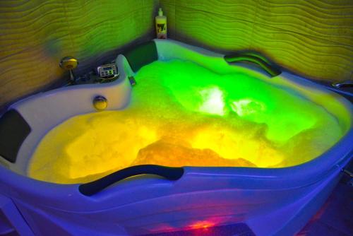 a bath tub filled with green and yellow water at Apartmani Tajna in Paraćin