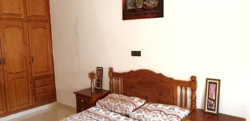 um quarto com uma cama de madeira e um armário de madeira em 2 bedrooms appartement at Oujda em Oujda