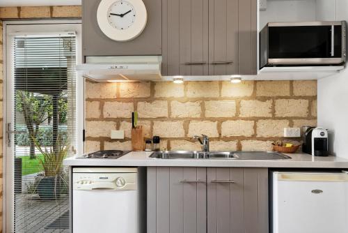 a kitchen with a sink and a clock on the wall at Seahaven Village in Barwon Heads