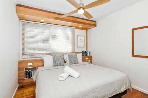 a bedroom with a bed with a ceiling fan at Seahaven Village in Barwon Heads