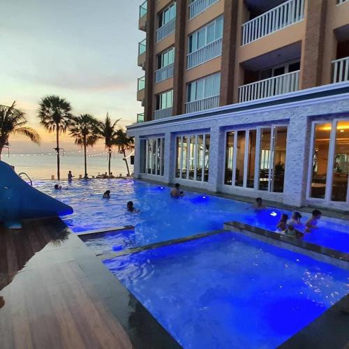a swimming pool with blue lighting in front of a building at Saisawan Beach Luxury Hotel in Na Jomtien