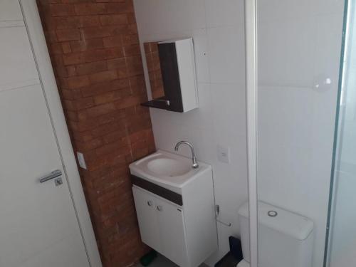 a small bathroom with a sink and a toilet at Apartamento FLAT no centro - Passo de Torres SC in Pirataba