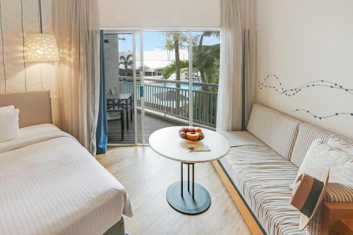 凯恩斯Shangri-La The Marina, Cairns的客厅配有沙发和带桌子的桌子