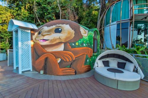 a mural of a lion sitting next to a bed at MyRus Resort Langkawi in Pantai Cenang