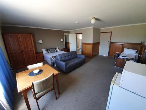 a room with a bed and a couch and a table at Robe Haven Motel in Robe