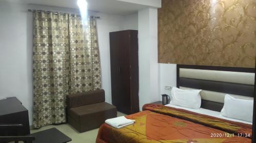 een slaapkamer met een bed en een stoel in een kamer bij Hotel Popular in Amritsar