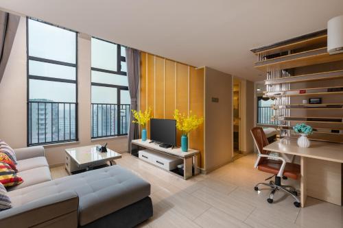 un soggiorno con un divano e un tavolo con una TV di Keluowei International Serviced Apartment Guangzhou Sun-yet.memorial Branch a Canton