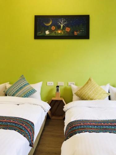 two beds in a room with a yellow wall at Mei Jung B&B in Zhixue