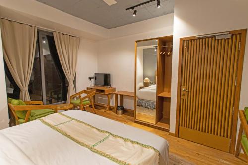 a bedroom with a bed and a desk and a television at Hotel Nova Boutique in Rajkot
