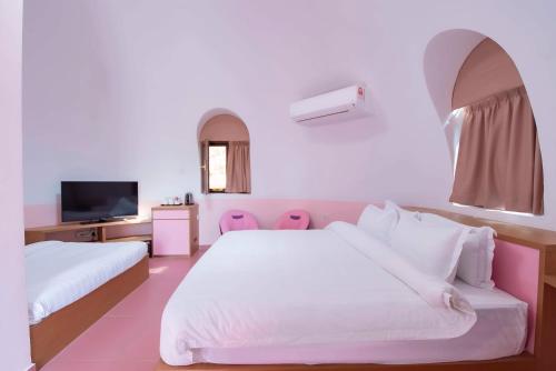 a hotel room with two beds and a tv at MyRus Resort Langkawi in Pantai Cenang