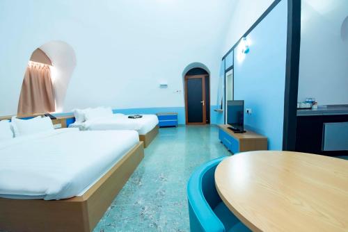 a hotel room with two beds and a television at MyRus Resort Langkawi in Pantai Cenang