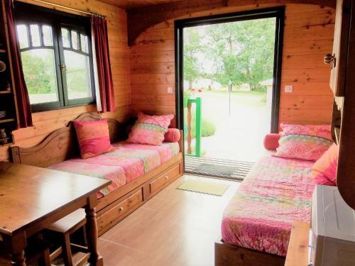 une chambre avec deux lits dans une cabane en rondins dans l'établissement Studio enchanteur à Pauilhac - 21 m² avec piscine partagée, à Pauilhac