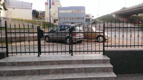 a car is parked next to a fence at Apartments Jasminka in Solin