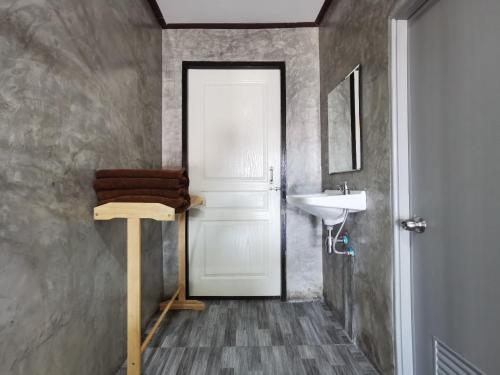 a bathroom with a white door and a sink at Viman Resort in Chon Buri