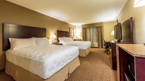 a hotel room with two beds and a flat screen tv at Holiday Inn Hotel and Suites-Kamloops, an IHG Hotel in Kamloops