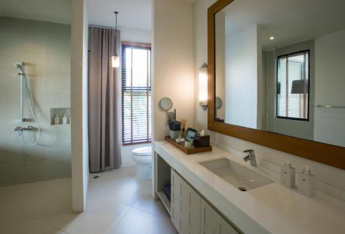 a bathroom with a sink and a toilet and a mirror at Sirinati Khao Kho in Khao Kho