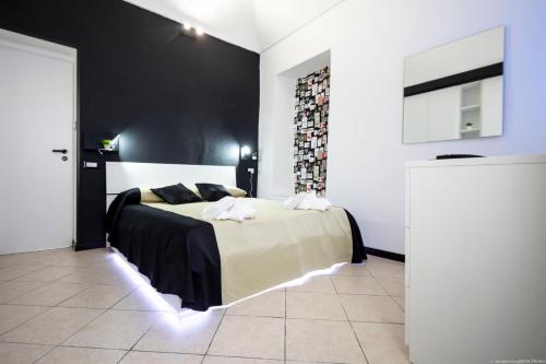 - une chambre avec un lit et un mur noir dans l'établissement HomeHoliday 2,0 - MY PLACE SANREMO, à Sanremo