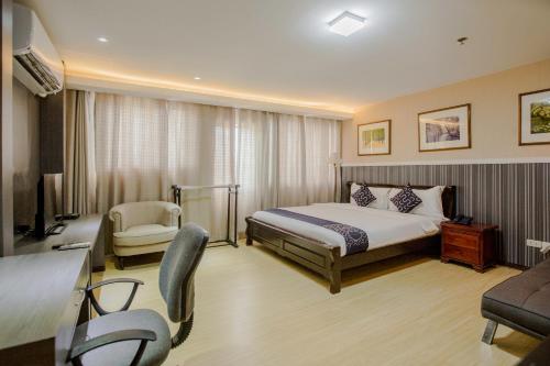 Habitación de hotel con cama y silla en Newgrange Condotel en Manila