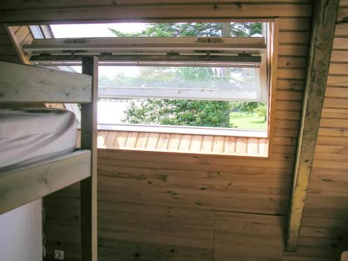 a window in a wooden cabin with a bunk bed at Maison confortable à Plehedel avec cheminée in Pléhédel