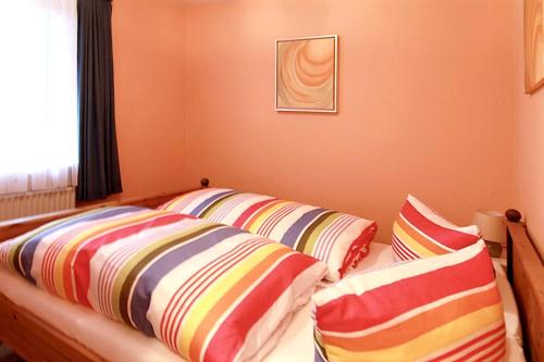 a room with three pillows on a bed with a window at Comfortable apartment with sea view in Westerland-Sylt, 35 m² in Westerland (Sylt)