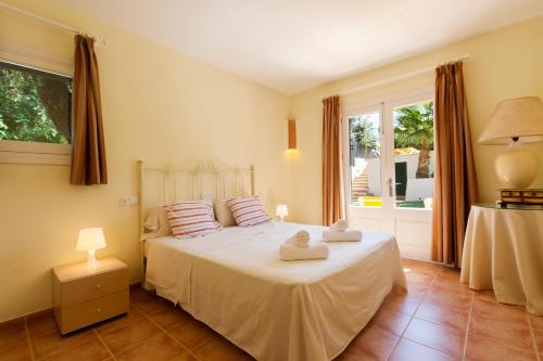 ポリェンサにある4 bedrooms villa at Pollensa 100 m away from the beach with sea view private pool and enclosed gardenのベッドルーム1室(ベッド1台、タオル2枚付)