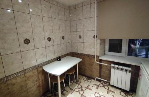クルィヴィーイ・リーフにあるАпартаменты в центре Металлургов 27 KR Apartmentsの小さなキッチン(白いテーブル、スツール2脚付)