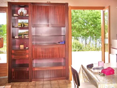 a kitchen with a wooden book shelf next to a table at Chalet de 3 chambres avec vue sur le lac piscine partagee et jardin amenage a Saint Gerons a 1 km de la plage in Saint-Gérons