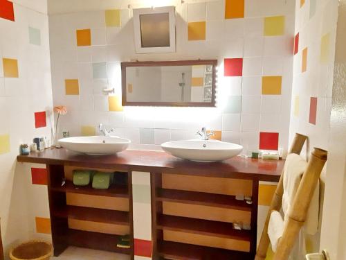 a bathroom with two sinks and a mirror at 3 bedrooms house at Cap Skirring 50 m away from the beach with sea view furnished terrace and wifi in Kabrousse