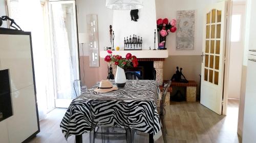 a dining room with a zebra print table and a fireplace at Maison charmante à La Londe-les-Maures, jardin clôturé in La Londe-les-Maures