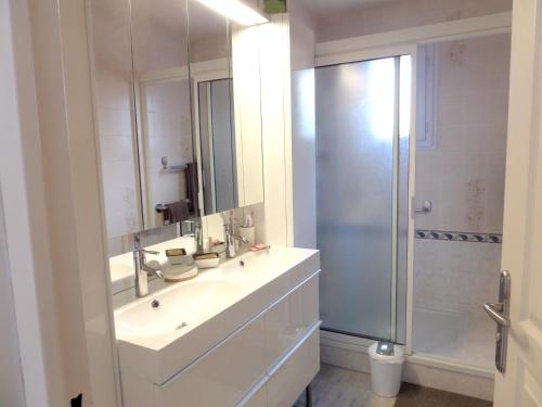 a white bathroom with a sink and a shower at Maison charmante à La Londe-les-Maures, jardin clôturé in La Londe-les-Maures